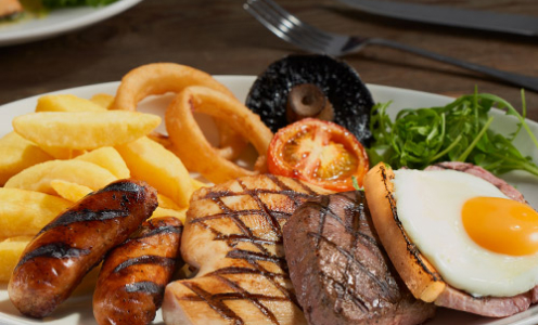 Beefeater Mixed Grill with chips, sausages, gammon, steak, chicken, a fried egg, onion rings, mushrooms and tomatoes.
