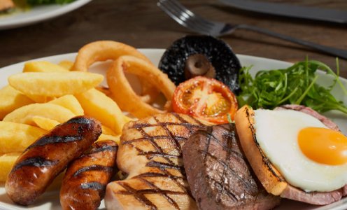 Beefeater Mixed Grill with chips, sausages, gammon, steak, chicken, a fried egg, onion rings, mushrooms and tomatoes.